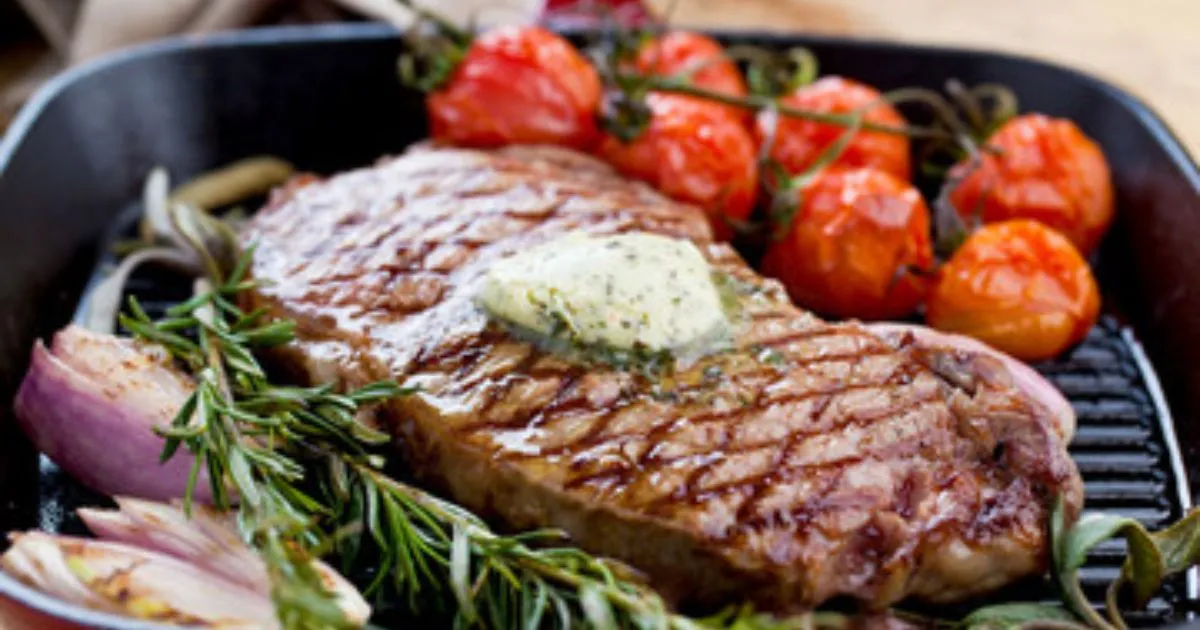 A close-up of a sizzling Beef Chuck Eye Steak cooked to perfection, showcasing its rich marbling and seared crust.